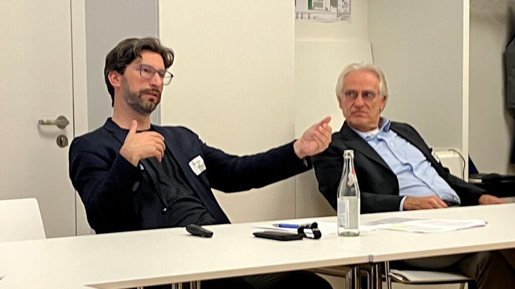 Sebastian Büttner (Transfer Unit Wissenschaftskommunikation der Berlin-Brandenburgischen Akademie der Wissenschaften) bei seiner Keynote zum Thema "Transfer aus der Perspektive der Wissenschaftsforschung". Neben ihm sitzt Christoph Weller (Universität Augsburg).